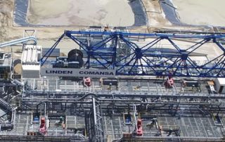 Birds eye view of a blue crane, scaffoldings and mining structures below it